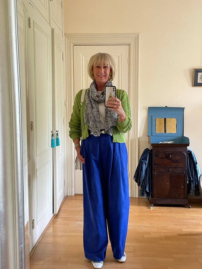 Blue trousers with a green cardigan