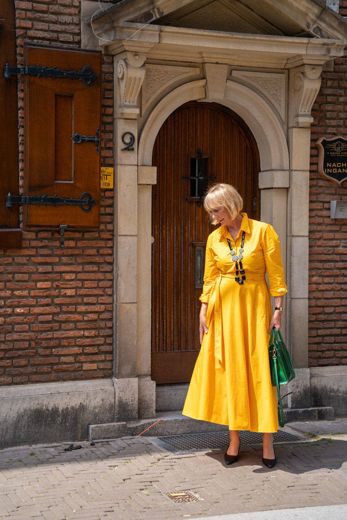 Bright yellow dress with a black and white necklace