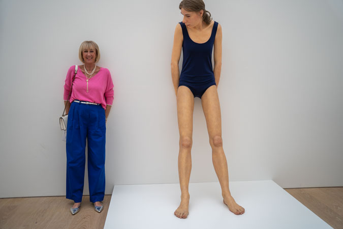 Bright blue trousers with a pink top and Ron Mueck