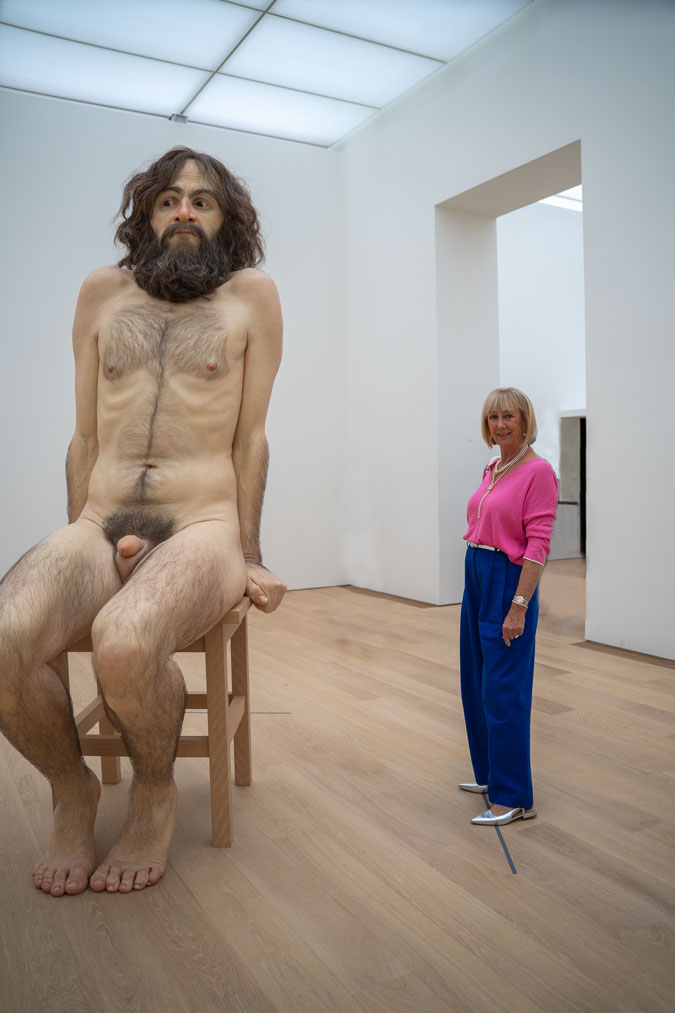 Bright blue trousers with a pink top and Ron Mueck