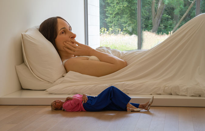 Bright blue trousers with a pink top and Ron Mueck