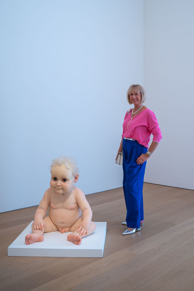 Bright blue trousers with a pink top and Ron Mueck