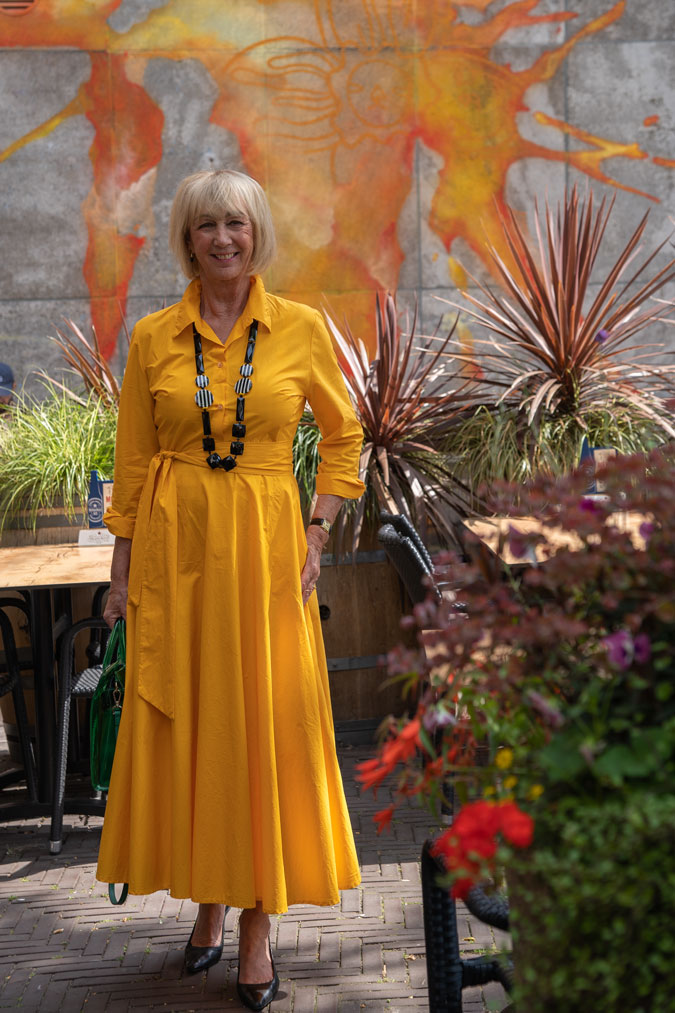 Bright yellow dress with a black and white necklace