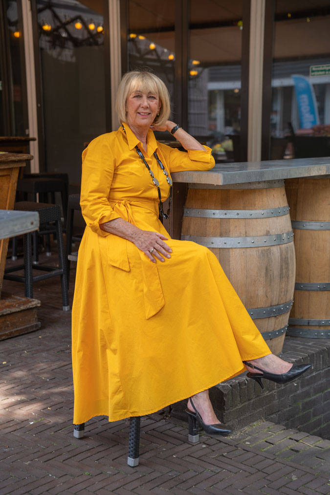 Bright yellow dress with a black and white necklace