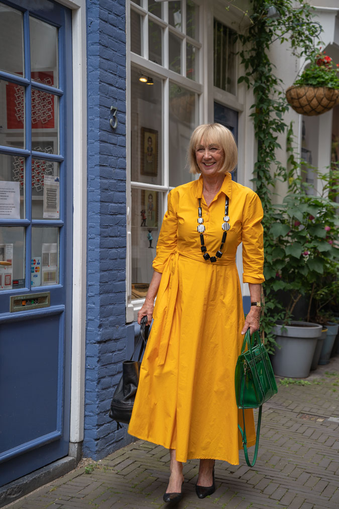 Bright yellow dress with a black and white necklace